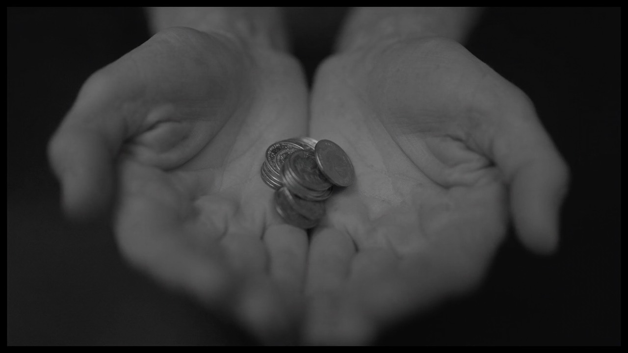 Open cupped hands gently holding a few coins