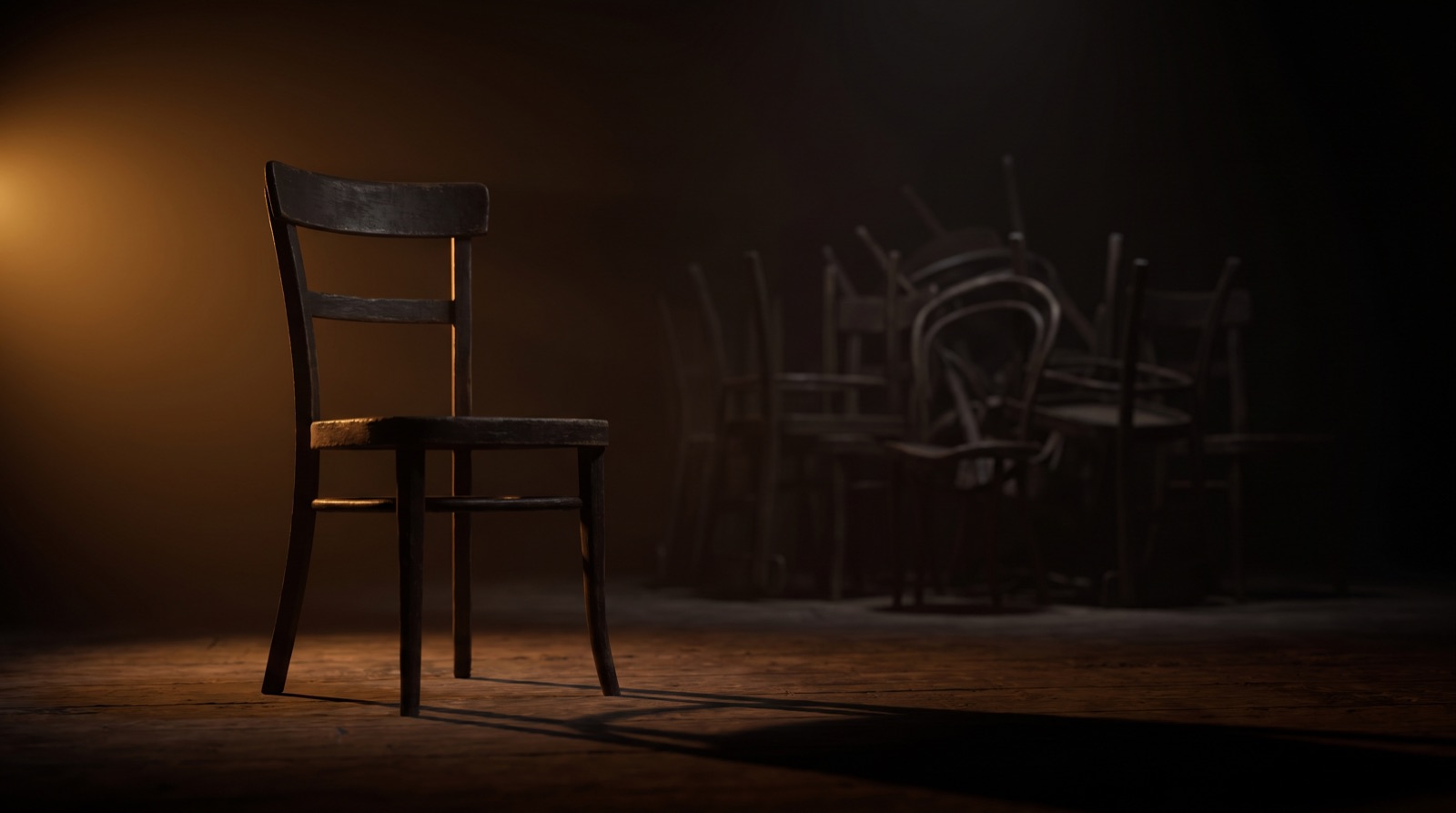 A single empty chair in a dark room of stacked chairs